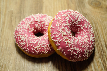 Rosa Donuts auf holz Hintergrund 