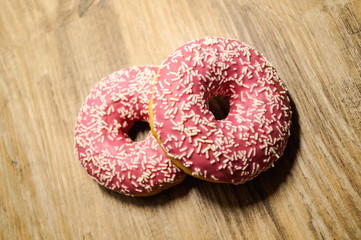 Rosa Donuts auf holz Hintergrund 