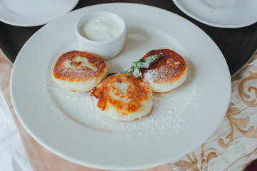 cheesecakes with sour cream and mint on a white plate