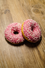 Rosa Donuts auf holz Hintergrund 