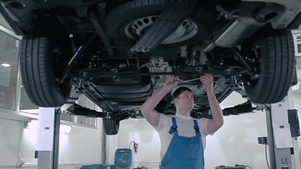An employee checks rail fastening with a stick.