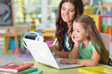 mother and daughter using laptop
