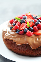 Homemade chocolate cake with berries on grey wooden table