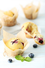 Muffins with blueberries on blue wooden table