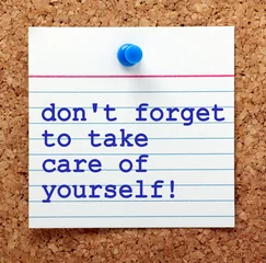 Foto op Canvas The words Don't Forget to Take Care of Yourself on a note card pinned to a cork notice board as a reminder to look after our own mental and physical health © thinglass