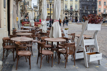Fototapeta na wymiar Empty tables of outdoor cafe in city center of Lviv, Ukraine in Europe