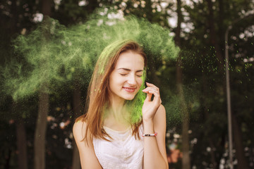 Fototapeta premium Pretty brunette woman posing with dry paint Holi
