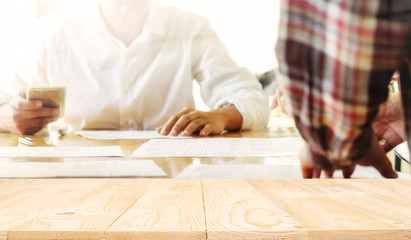 Wooden desk space platform with business people in a meeting at office vintage tone. For product display montage.