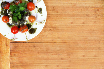Caprese salad tomato and mozzarella with parsley and herbs on a