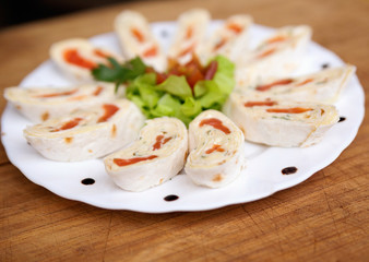 appetizer with salmon in pita bread decorated with tomato, salad