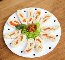 appetizer with salmon in pita bread decorated with tomato, salad
