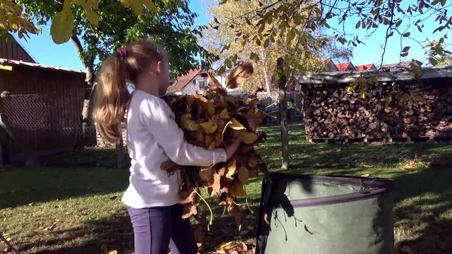 Mädchen sammelt im Garten die Nußblätter - Gartenarbeit im Herbst, 4K