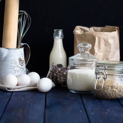 Ingredients for oatmeal cookies (oat flakes, sugar, eggs, milk) on the wooden background or table. Daily product
