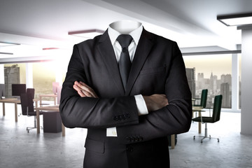 businessman without head standing in office crossed arms