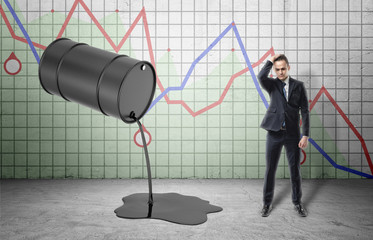 Inclined barrel with oil pouring out of it and frustrated businessman