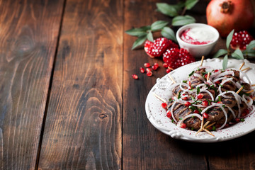 Grilled minced meat skewers kebabs with onions, sumac and pomegranate, selective focus