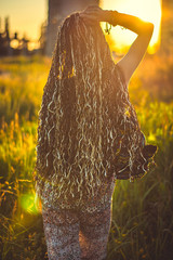 Young woman with afro cornrows on sunset. Soft sunset light