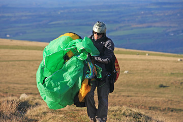 Paraglider carrying his wing