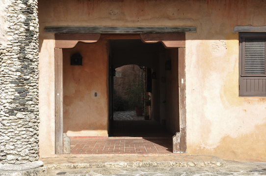Photo of the entrance to the old house in the Spanish style with a pillar of stone