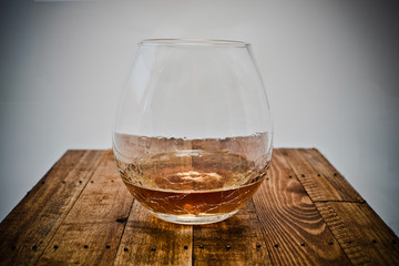 a glass of brandy on wooden background