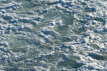 Sea water surface with white foam