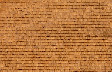 Large wooden house wall of shingles in the evening sun