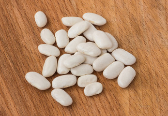 Fototapeta na wymiar White beans closeup on a wooden background.