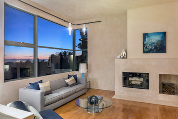 Beautiful living room with hardwood floors, fire place at night.