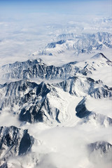 Mountains in snow and clouds. View from above. Winter nature.