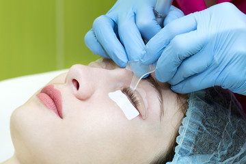 Woman on the procedure for eyelash extensions, eyelashes lamination