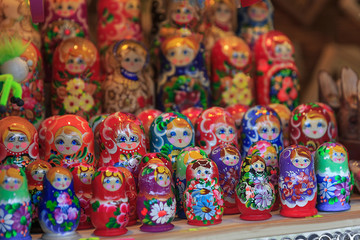Colorful close up details of christmas fair market. Wooden matrioshka decorations for sales. Russian dolls