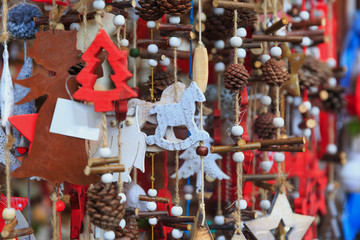 Colorful close up details of christmas fair market. Stars, hearts, tree, fir-cone balls decorations for sales.