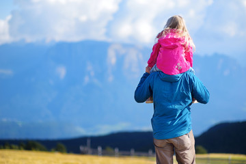 Father and his daughter admiring a view of stunning rocky Dolomites mountains of South Tyrol