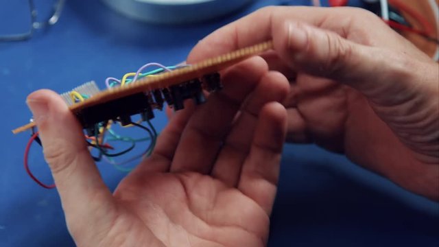 close-up shot of an electronics engineer developing and soldering a electronic circuit on a perfboard