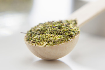 Aromatic herbs are in the small spoon close-up. Spice for cooking food on a white background. 