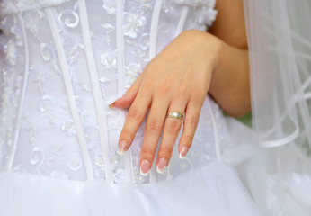 bride hands with ring over the wedding dress