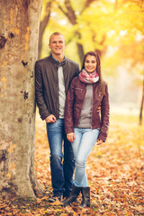 Fototapeta na wymiar Young couple are enjoying therig time together in a park on a beautiful Autumn day.