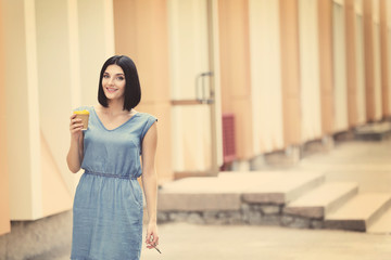 Fototapeta premium Young beautiful girl outdoors with cup of coffee