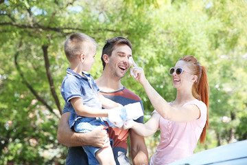 Happy family washing car on street