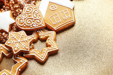 Tasty gingerbread cookies and Christmas decor on textured background