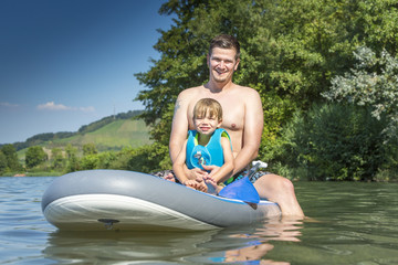 Father and son together having fun on a surfboard