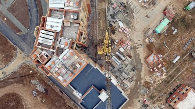 Aerial view of a large construction site with many cranes. View directly from above. 4K.
