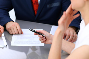 Business lady offering businessman black pen for signing a contract