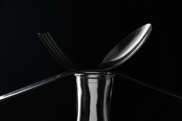 fork and spoon isolated on black background
