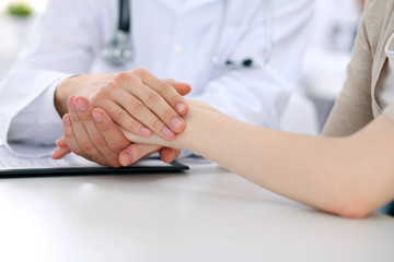 Hand of doctor reassuring her female patient