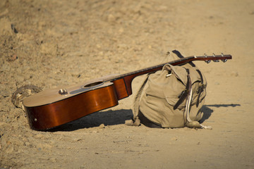 The guitar and backpack lying beside the road