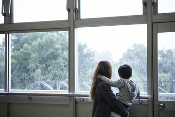 Mother is looking out of the window to hug his son