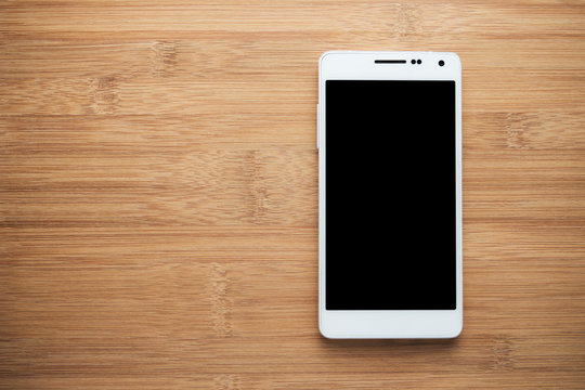 White smart phone with isolated screen on old wooden