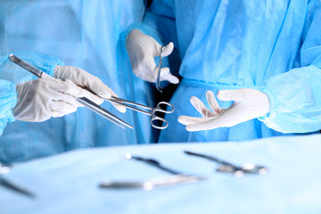 Medical team performing operation. Group of surgeon is working in operating theatre toned in blue