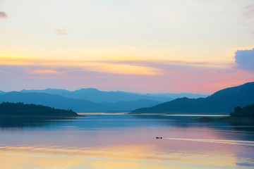 Naklejka premium Colorful evening clouds above the dam and mountains from thailand,copy space.